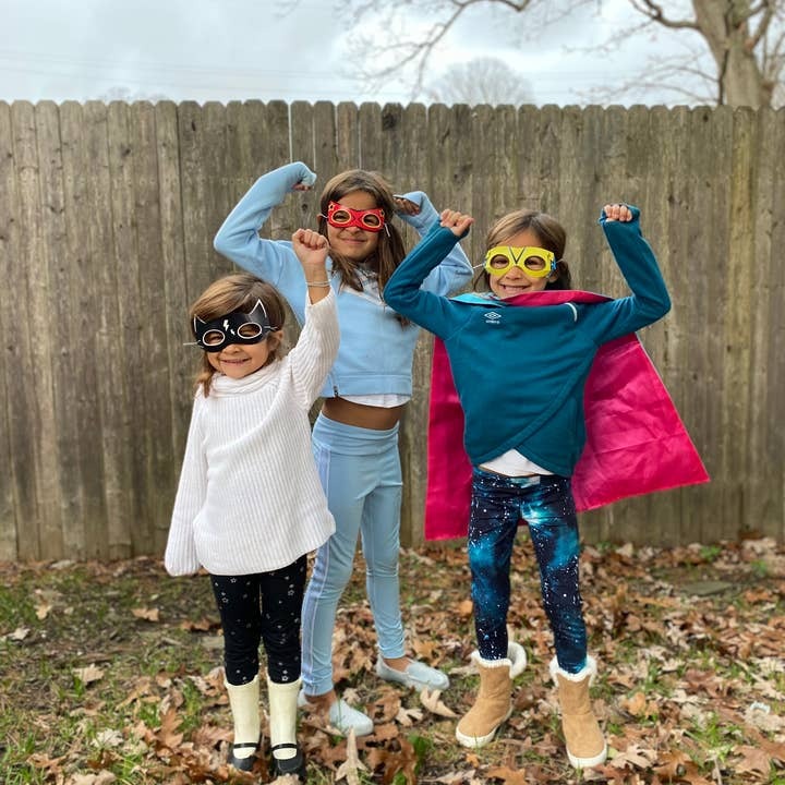 Colorful kids superhero masks and cape costume with children posing outdoors birthday from Parte Haus party supply store in Bethesda Maryland