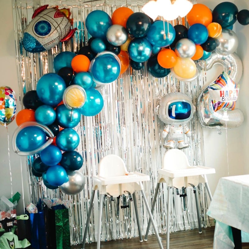 Blue and orange space theme balloon arch with astronaut and rocket decorations birthday from Parte Haus party supply store in Bethesda MD