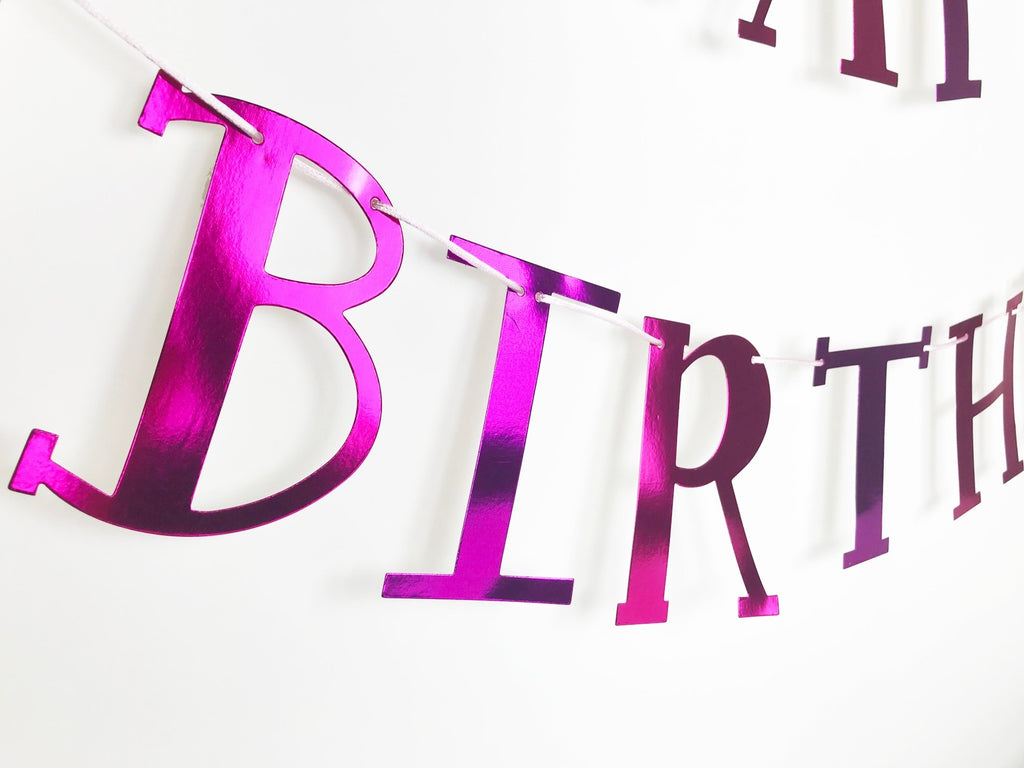 Pink metallic birthday banner with large bold letters for birthday celebration from Parte Haus party supply store in Bethesda MD