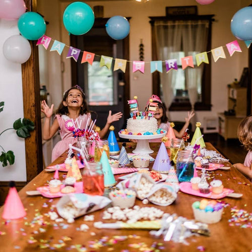 Colorful birthday table and decorations with balloons and cake for kids celebration from Parte Haus party supply store in Bethesda MD.