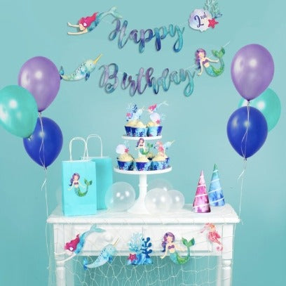 Blue and purple mermaid themed birthday decoration set with balloons and hats from Parte Haus party supply store in Bethesda, Maryland.