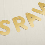 Gold banner letters strung on twine for celebration theme from Parte Haus party supply store in Bethesda MD.