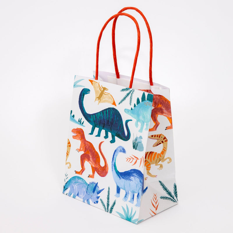 Colorful dinosaur gift bag with orange handles for kids birthday from Parte Haus party supply store in Bethesda, Maryland.