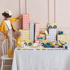 Yellow construction birthday table decor with toy trucks and city buildings from Parte Haus party supply store in Bethesda MD