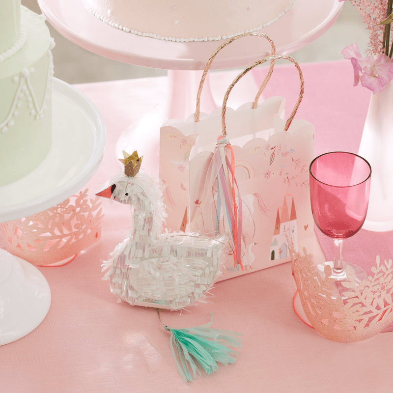 White swan pinata princess theme with pink goodie bag on table from Parte Haus party supply store in Bethesda MD