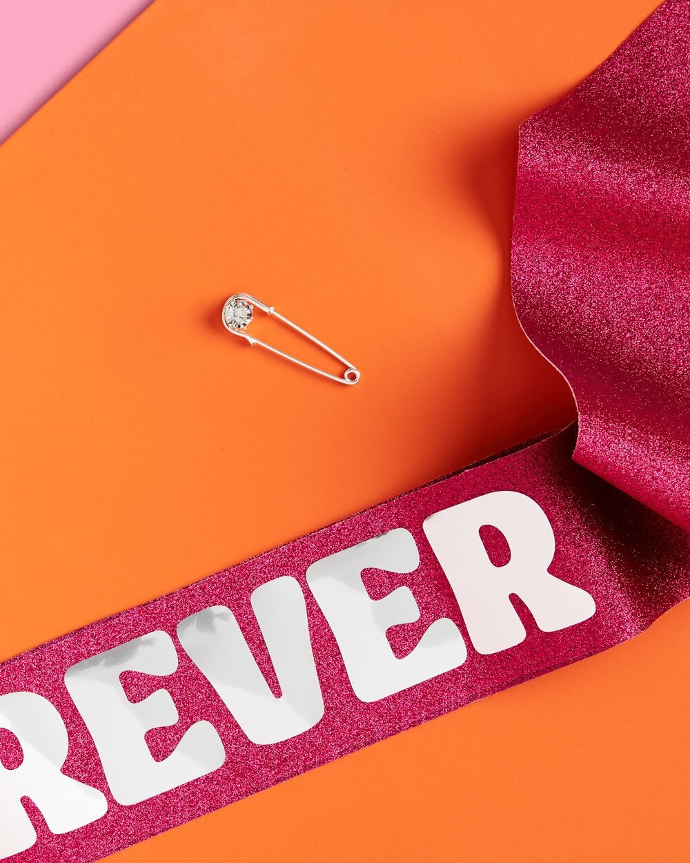 Pink glitter birthday sash with bold white letters for birthday party from Parte Haus party supply store in Bethesda Maryland