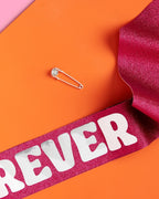 Pink glitter birthday sash with bold white letters for birthday party from Parte Haus party supply store in Bethesda Maryland