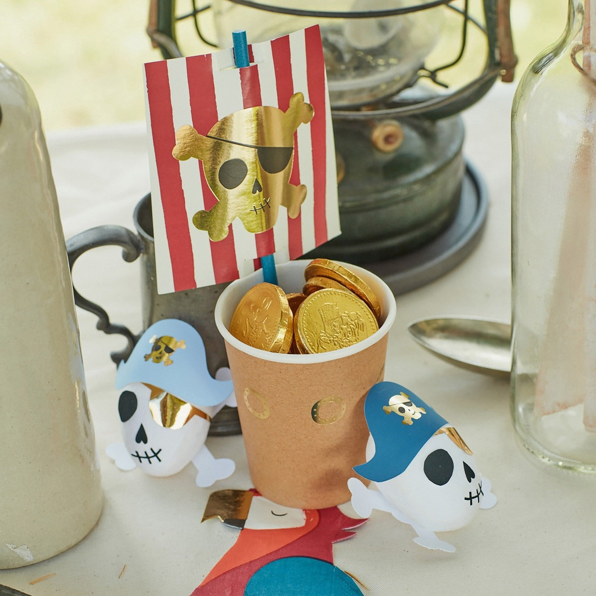 Gold pirate cup with chocolate coins and pirate skull decorations for kids birthday from Parte Haus party supply store in Bethesda Maryland