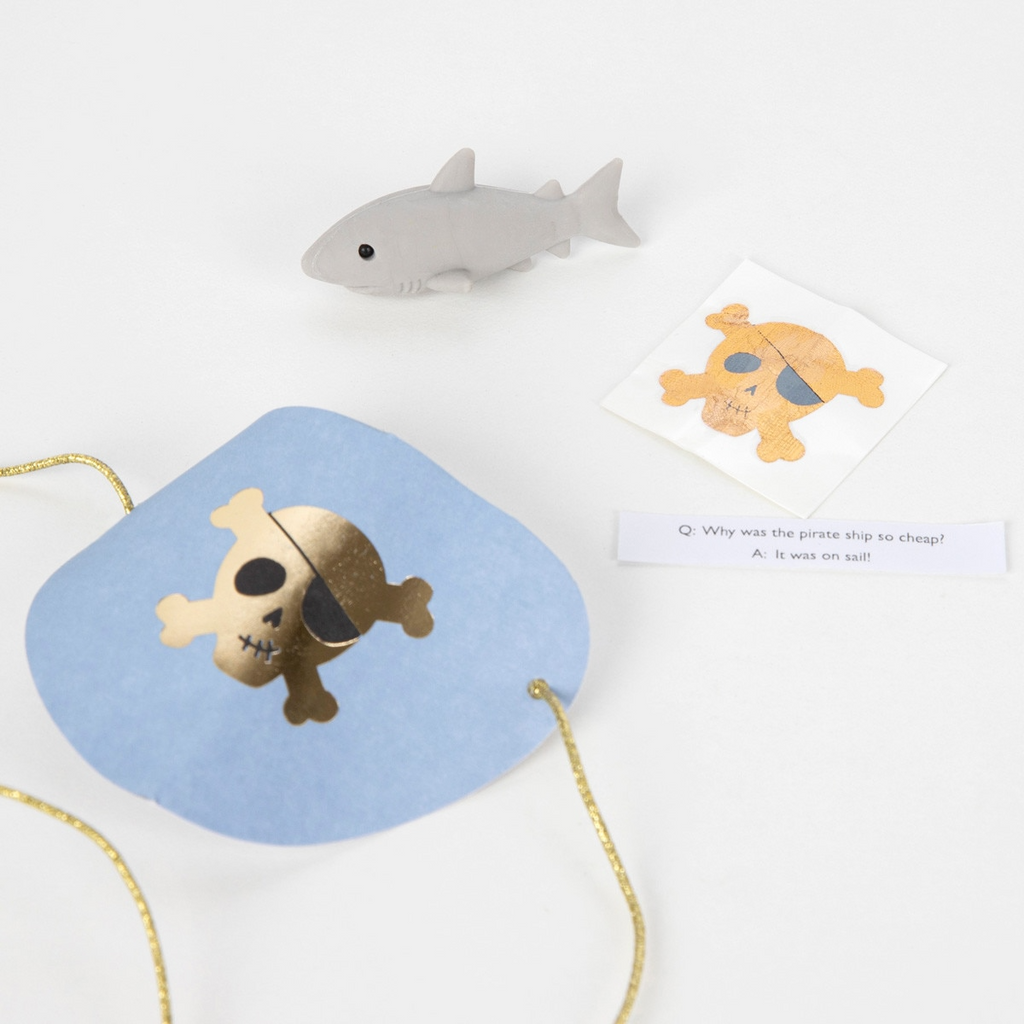 Blue pirate mask with gold skull sticker and gray shark toy for pirate party from Parte Haus party supply store in Bethesda MD