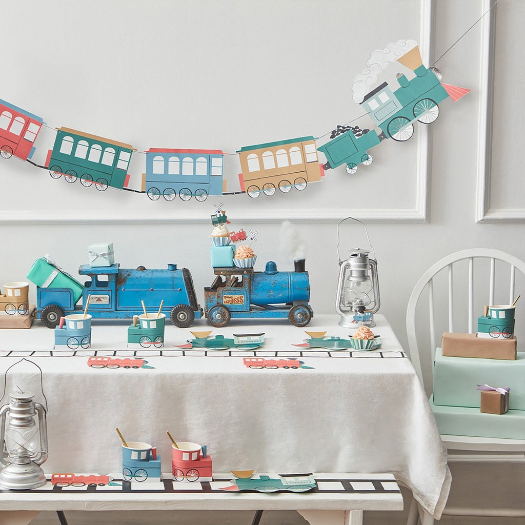 Blue and pastel train birthday party decorations with tableware and garland from Parte Haus party supply store in Bethesda Maryland