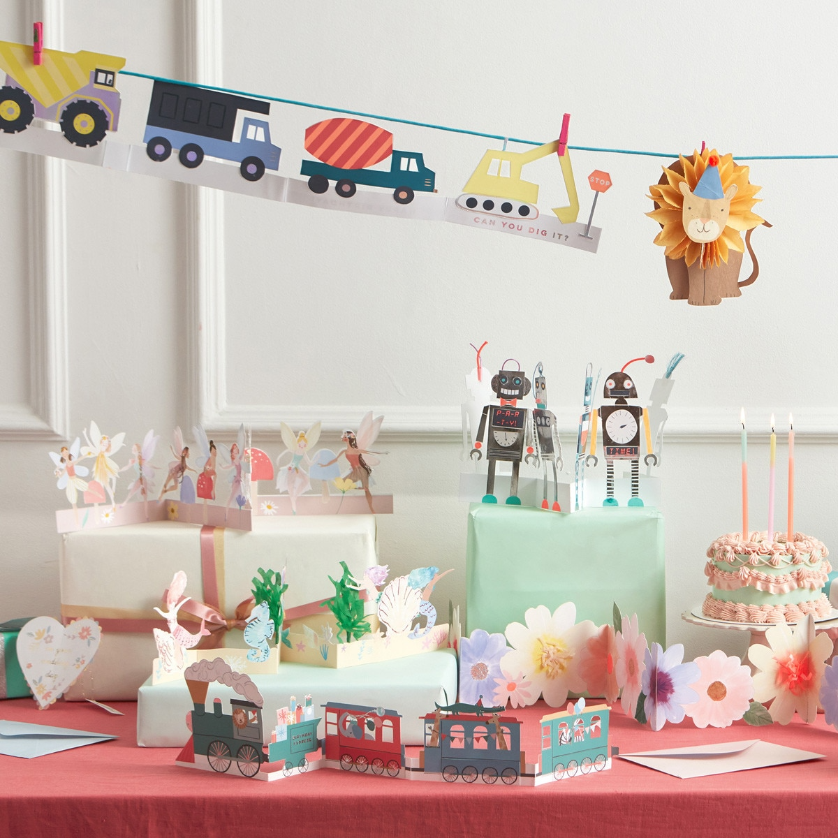 colorful birthday decorations with robot and fairy cake toppers and train banner kids theme from Parte Haus party supply store in Bethesda Maryland