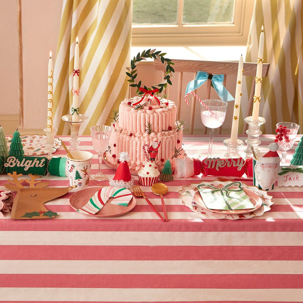 Pink Christmas table setting with striped tablecloth, cake, and festive decor from Parte Haus party supply store in Bethesda MD