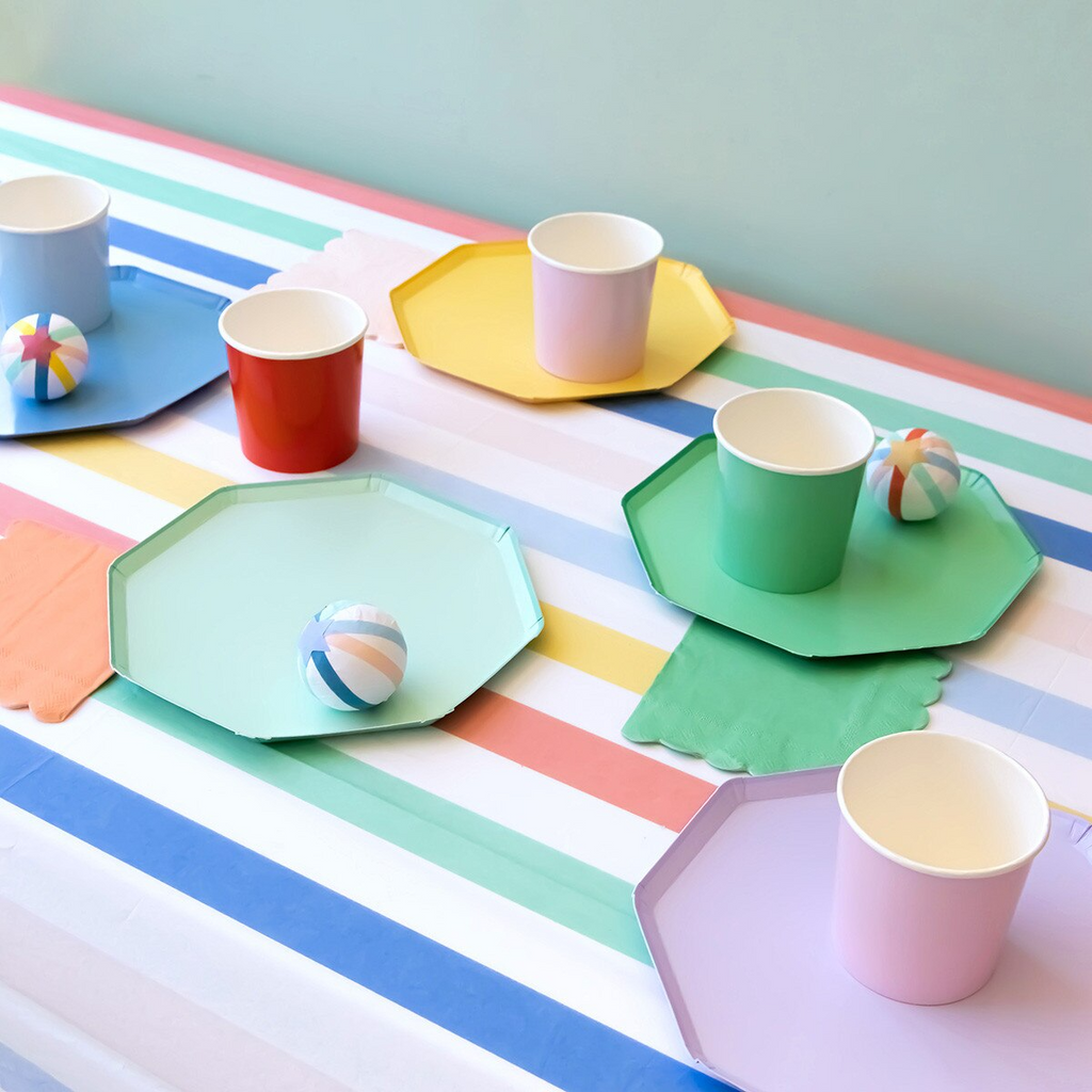 Pastel and bright striped plates and cups set for birthday on a colorful table from Parte Haus party supply store in Bethesda MD