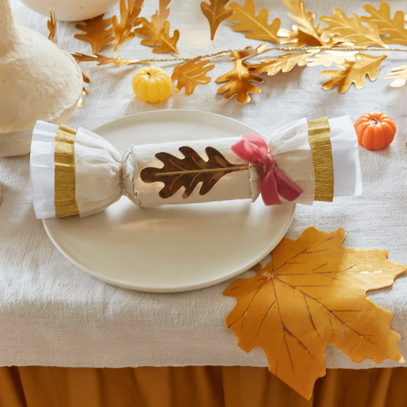 Gold and white Thanksgiving cracker with leaf design on a festive table from Parte Haus party supply store in Bethesda Maryland