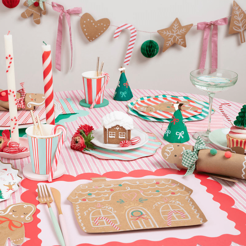 Red and green gingerbread house plate Christmas table setting with candy cane striped cups from Parte Haus party supply store in Bethesda Maryland