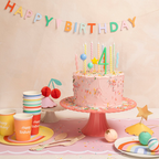 Pink rainbow birthday cake with candles and pastel tableware for kids party from Parte Haus party supply store in Bethesda MD