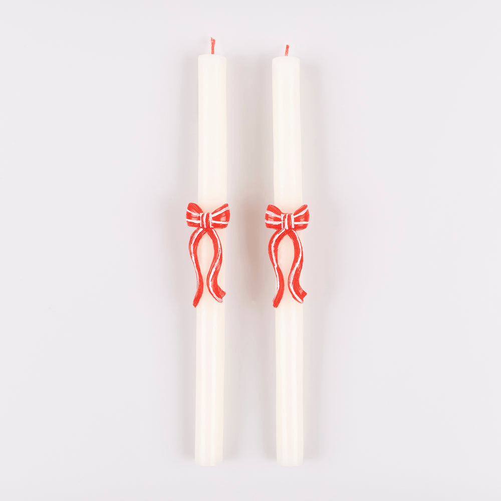 White taper candles with red bows festive decor from Parte Haus party supply store in Bethesda Maryland