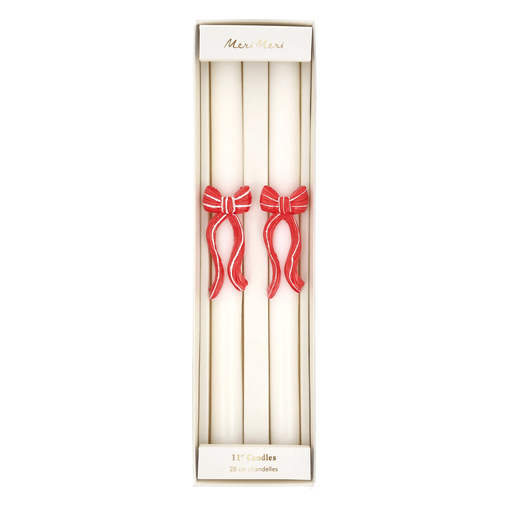 White taper candles with red bow accents perfect for holiday celebrations from Parte Haus party supply store in Bethesda MD