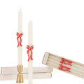 White taper candles with red bow accents holiday decor from Parte Haus party supply store in Bethesda Maryland