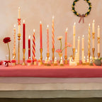 Red and pink taper candles with gold holders on a decorated table for holiday celebration from Parte Haus party supply store in Bethesda MD