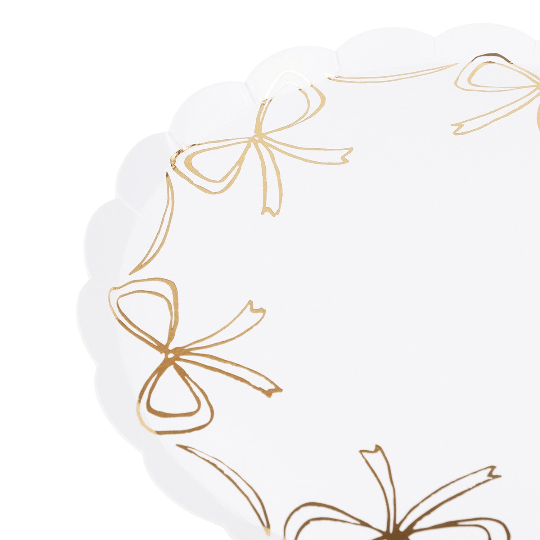 White and gold scalloped plate with bow accents for celebration from Parte Haus party supply store in Bethesda Maryland