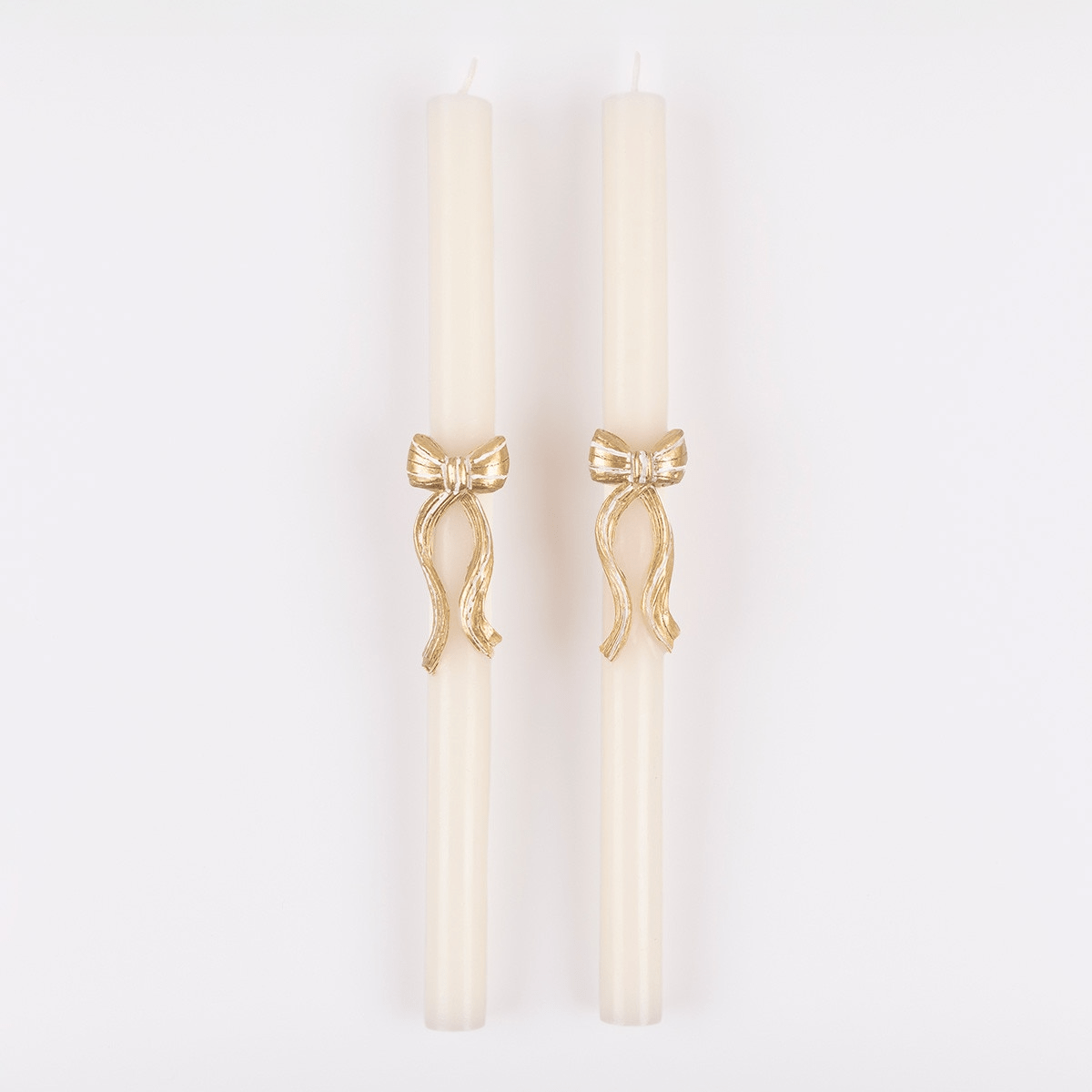 Ivory taper candles with gold bow accent for elegant dinner celebrations from Parte Haus party supply store in Bethesda MD