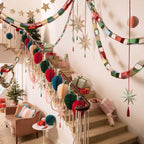 Multicolor Christmas garlands and ornaments decorate a staircase holiday decor from Parte Haus party supply store in Bethesda MD.