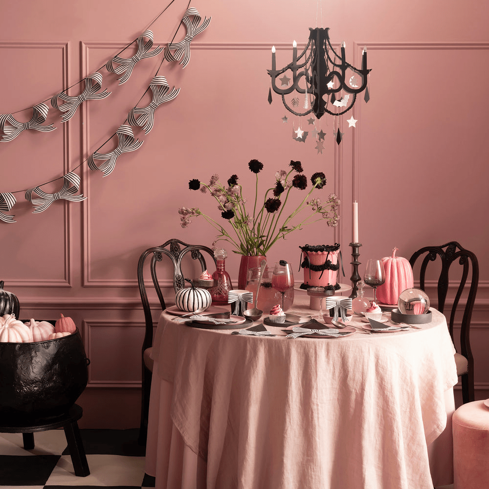 pink and black Halloween table decorations with striped banners and pumpkins party display from Parte Haus party supply store in Bethesda Maryland