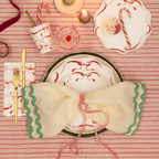 Red and white bow plate setting with gold cutlery and candy cane Christmas decor from Parte Haus party supply store in Bethesda Maryland