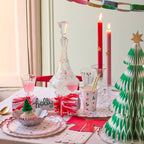 Red and green Christmas table decor with plates cups candles and tree for holiday from Parte Haus party supply store in Bethesda Maryland
