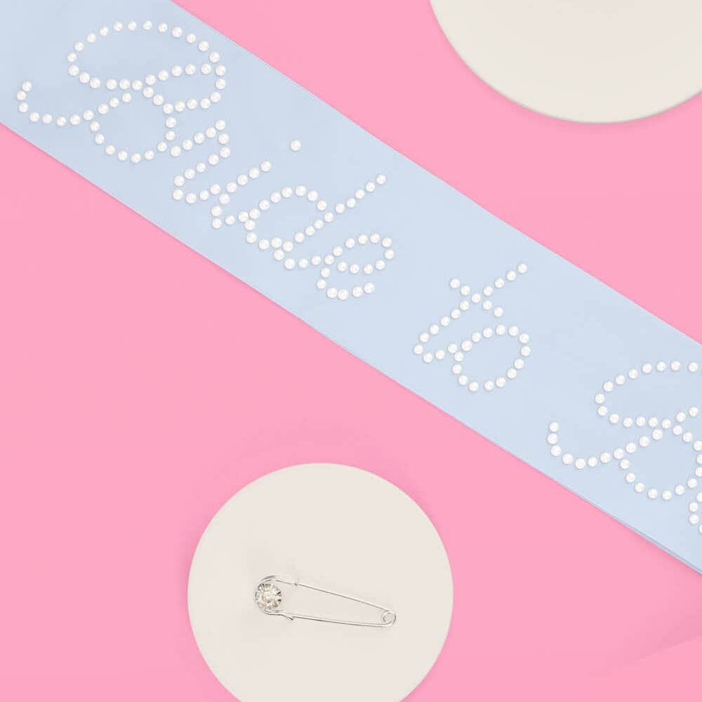 Light blue bride to be sash with pearl accents for bridal shower from Parte Haus party supply store in Bethesda Maryland