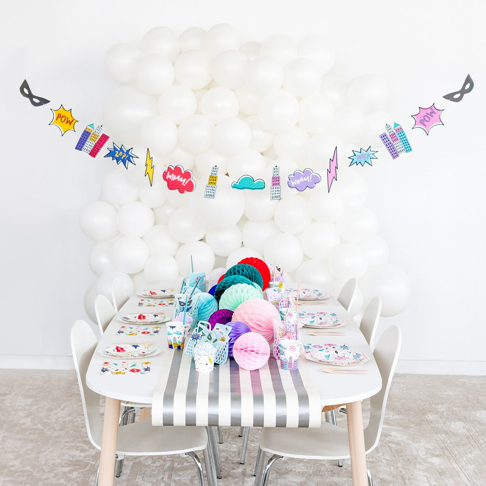 Colorful superhero theme birthday table decor with white balloon backdrop from Parte Haus party supply store in Bethesda MD