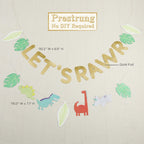Gold dinosaur theme banner with green leaves and cartoon dinosaurs birthday decoration from Parte Haus party supply store in Bethesda Maryland