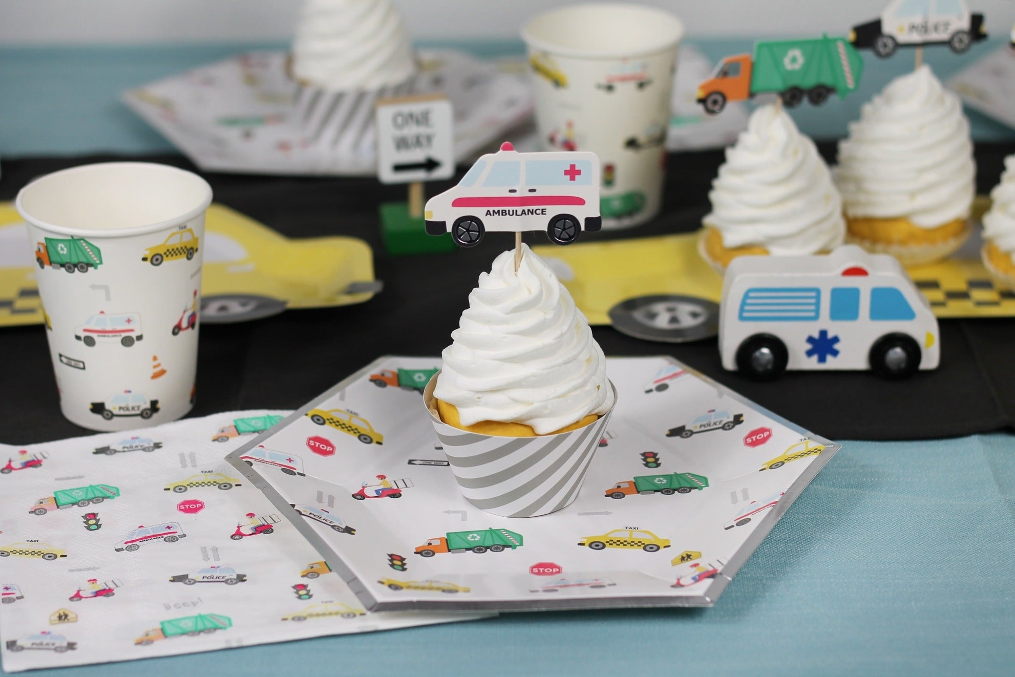 Multicolor vehicle themed plate cup and cupcake with ambulance topper birthday party from Parte Haus party supply store in Bethesda Maryland.