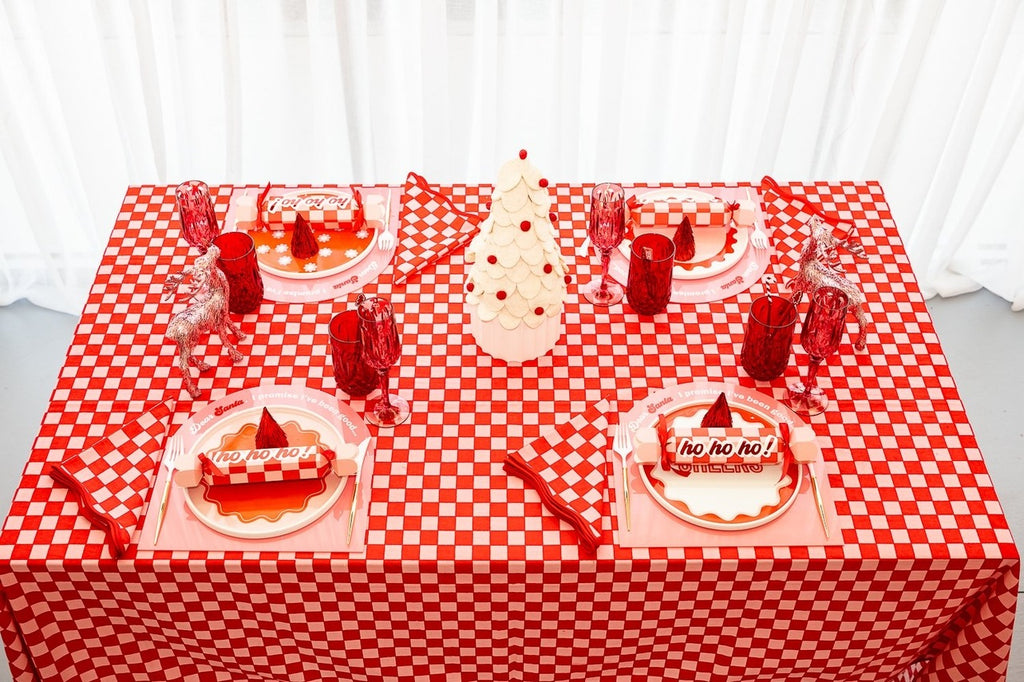 Red and white Christmas table setup with festive plates reindeer decor and tree centerpiece from Parte Haus party supply store in Bethesda Maryland