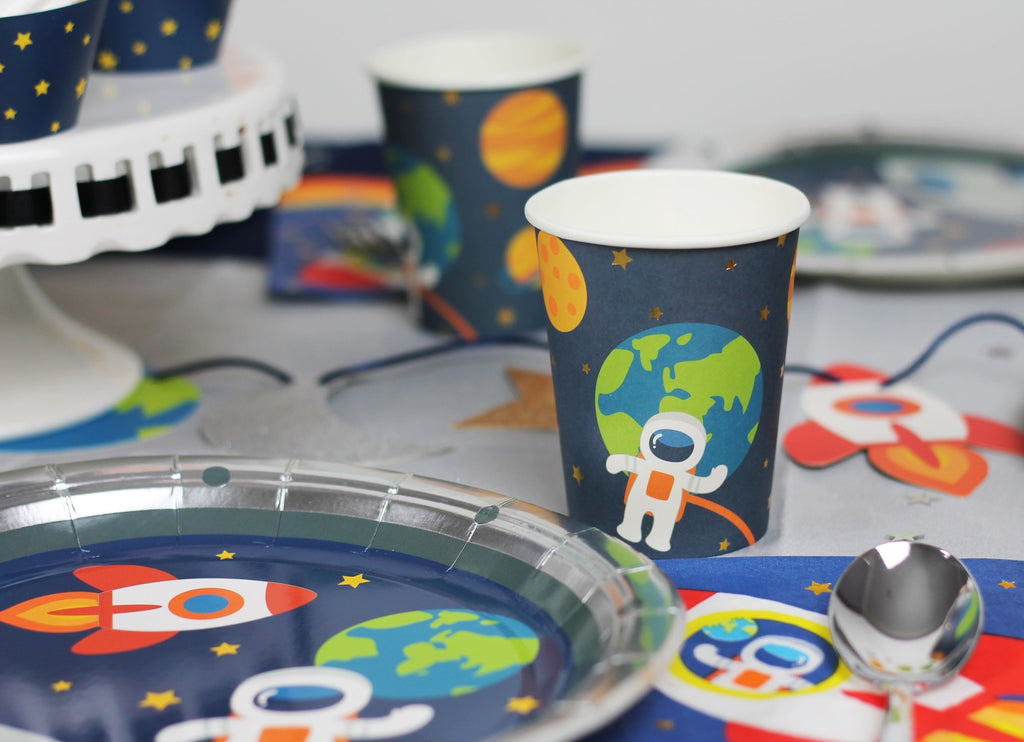 Blue space theme cups with astronaut design and matching plates for kids birthday from Parte Haus party supply store in Bethesda MD
