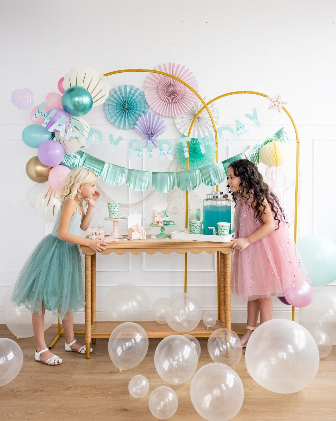 Aqua and pink birthday decoration table with balloons and two girls from Parte Haus party supply store in Bethesda MD