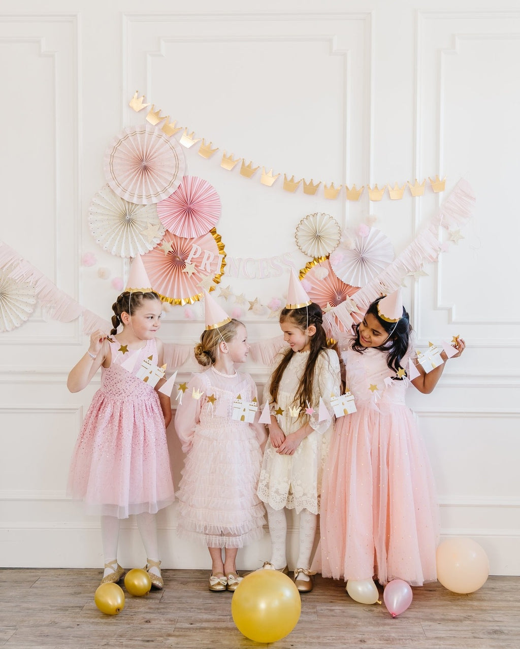 Pink and gold princess birthday decorations with girls in dresses from Parte Haus party supply store in Bethesda MD