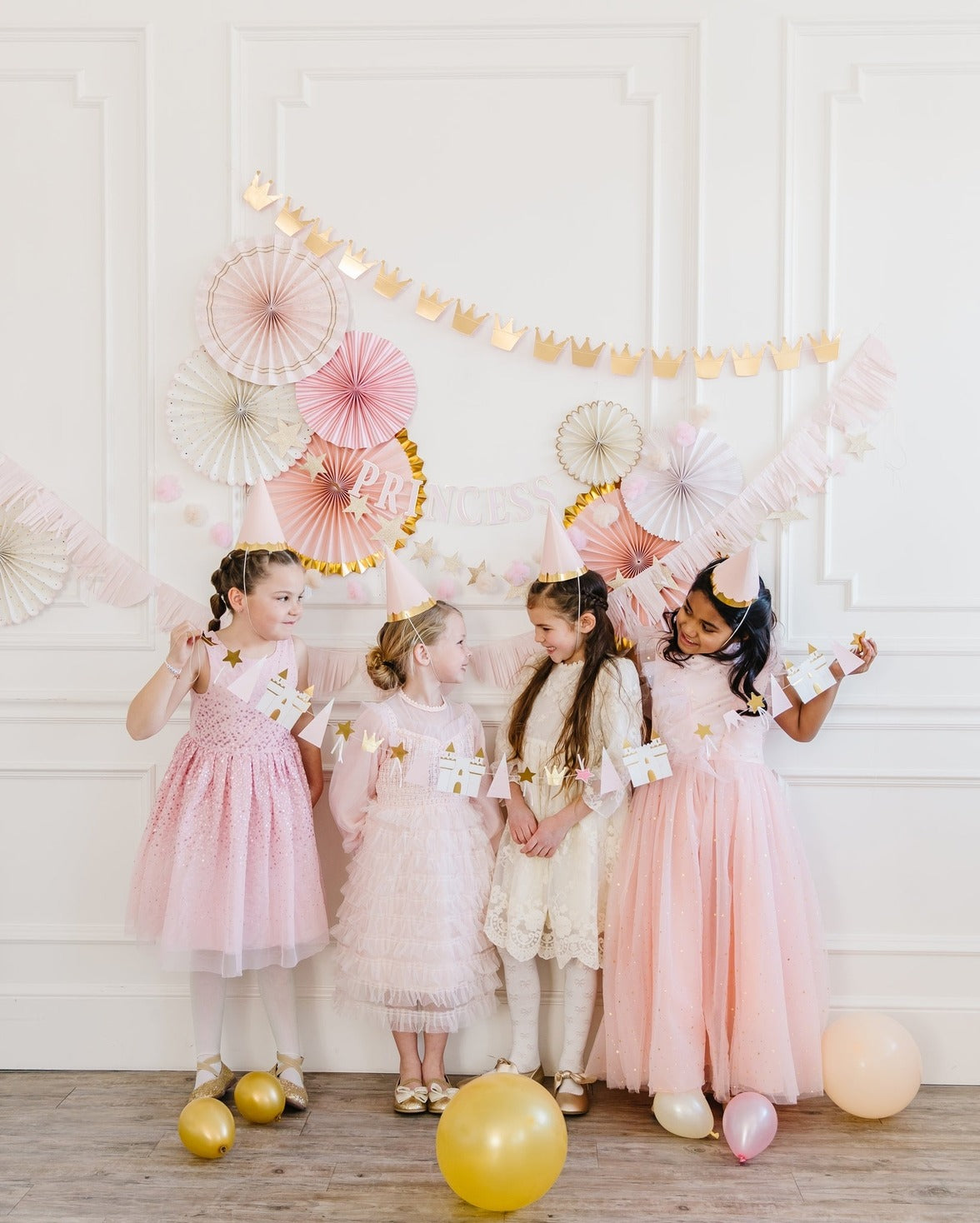 Pink and gold princess birthday decorations with girls in dresses from Parte Haus party supply store in Bethesda MD