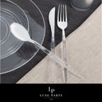 Clear plastic cutlery set with plates on a black and beige table setting for elegant events from Parte Haus party supply store in Bethesda MD