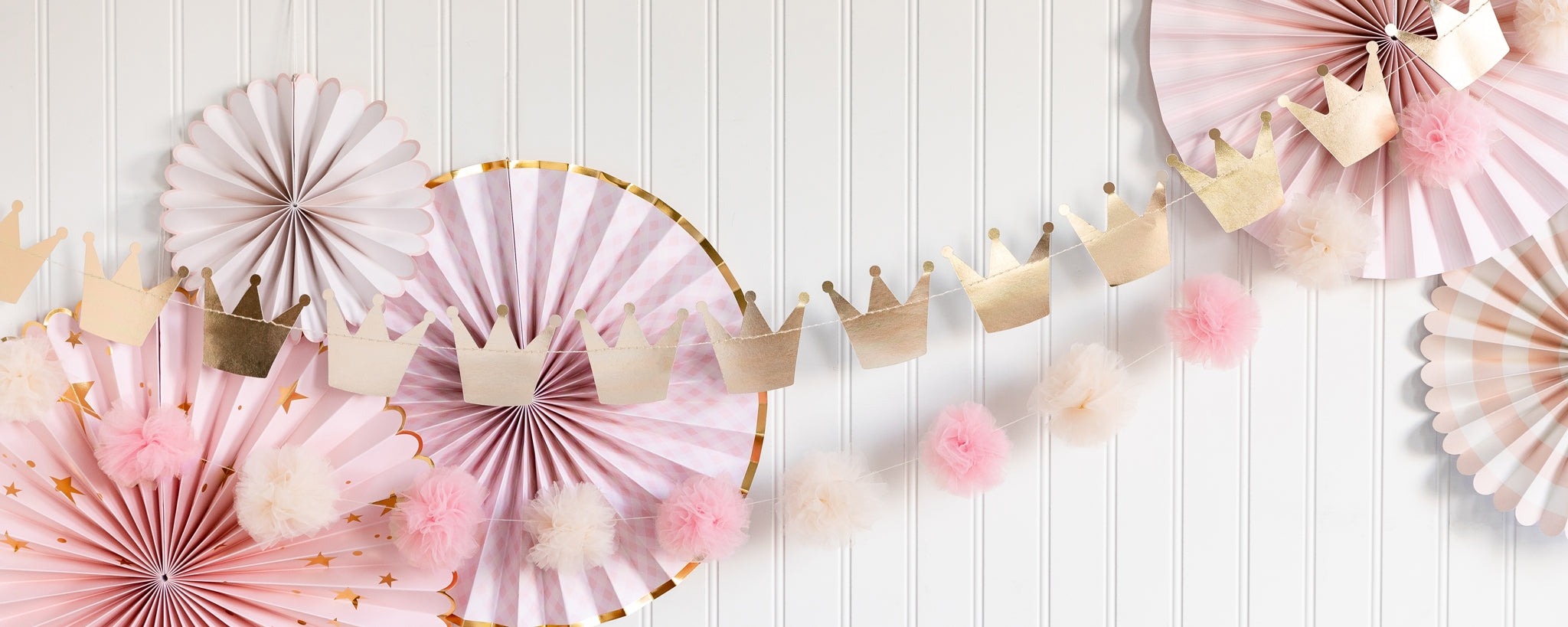 Pink and gold princess crown garland and paper fans birthday decoration from Parte Haus party supply store in Bethesda Maryland