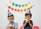Blue and orange space themed birthday hats worn by kids with cupcakes birthday celebration from Parte Haus party supply store in Bethesda MD
