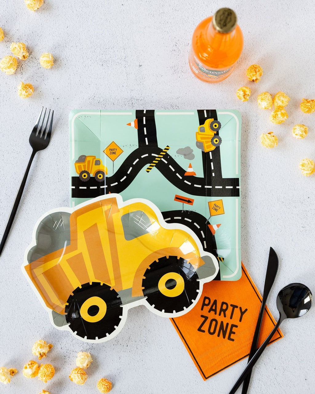 Yellow construction truck shaped plate and road map plate for construction birthday from Parte Haus party supply store in Bethesda MD