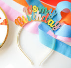 Rainbow metallic birthday headband with script text for birthday celebration from Parte Haus party supply store in Bethesda MD