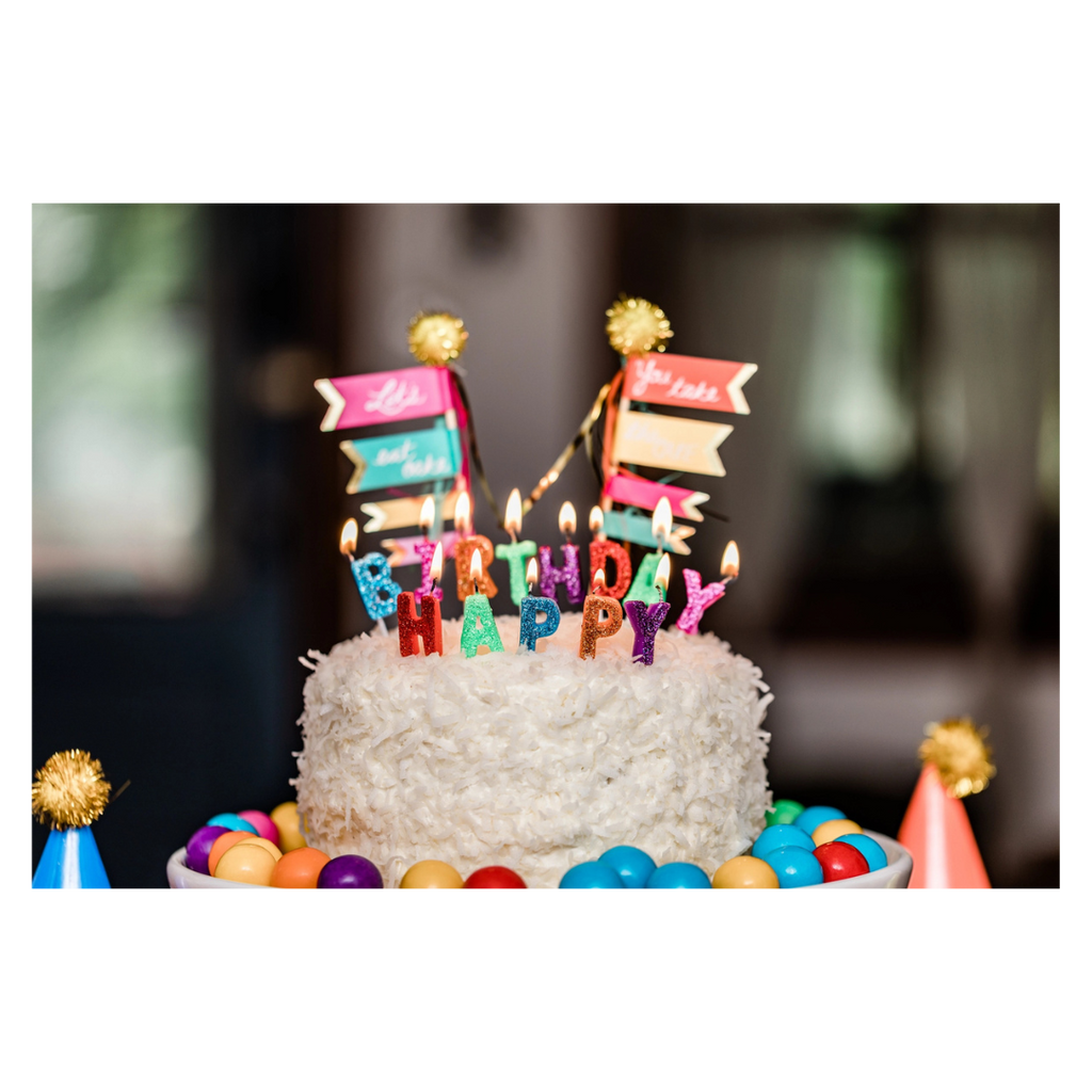 Colorful birthday cake with candles and candy decorations birthday theme from Parte Haus party supply store in Bethesda MD