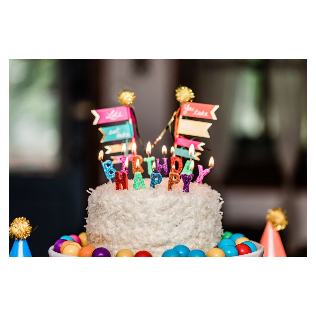 Colorful birthday cake with candles and candy decorations birthday theme from Parte Haus party supply store in Bethesda MD