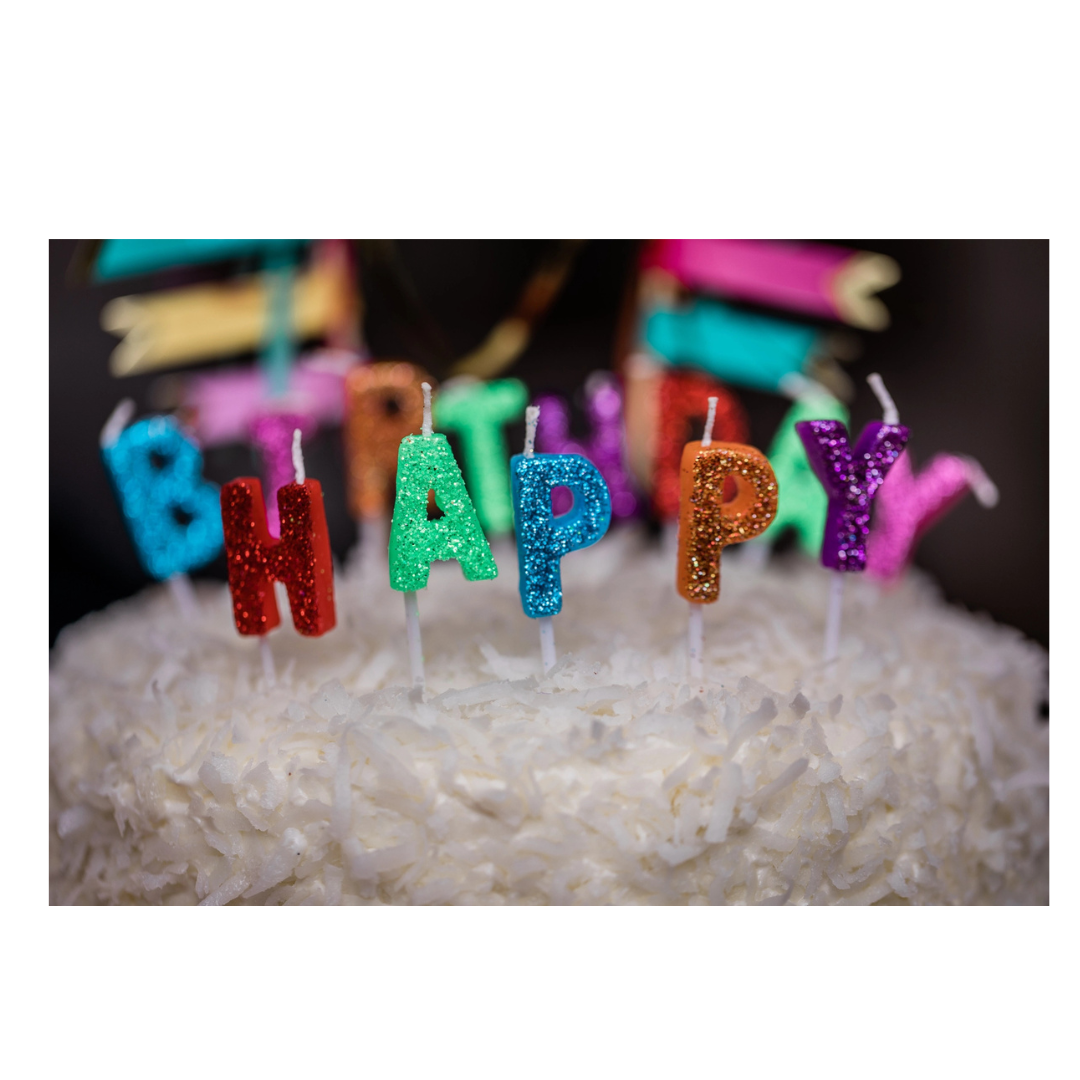 multicolor glitter birthday candles on white coconut cake birthday theme from Parte Haus party supply store in Bethesda Maryland