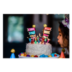 White birthday cake with colorful candles and rainbow flags kids celebration from Parte Haus party supply store in Bethesda MD.