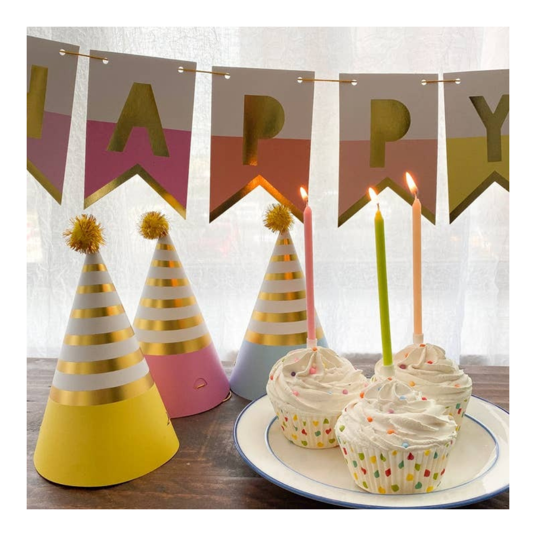 Pastel birthday hats banner and cupcakes with candles birthday decor from Parte Haus party supply store in Bethesda MD