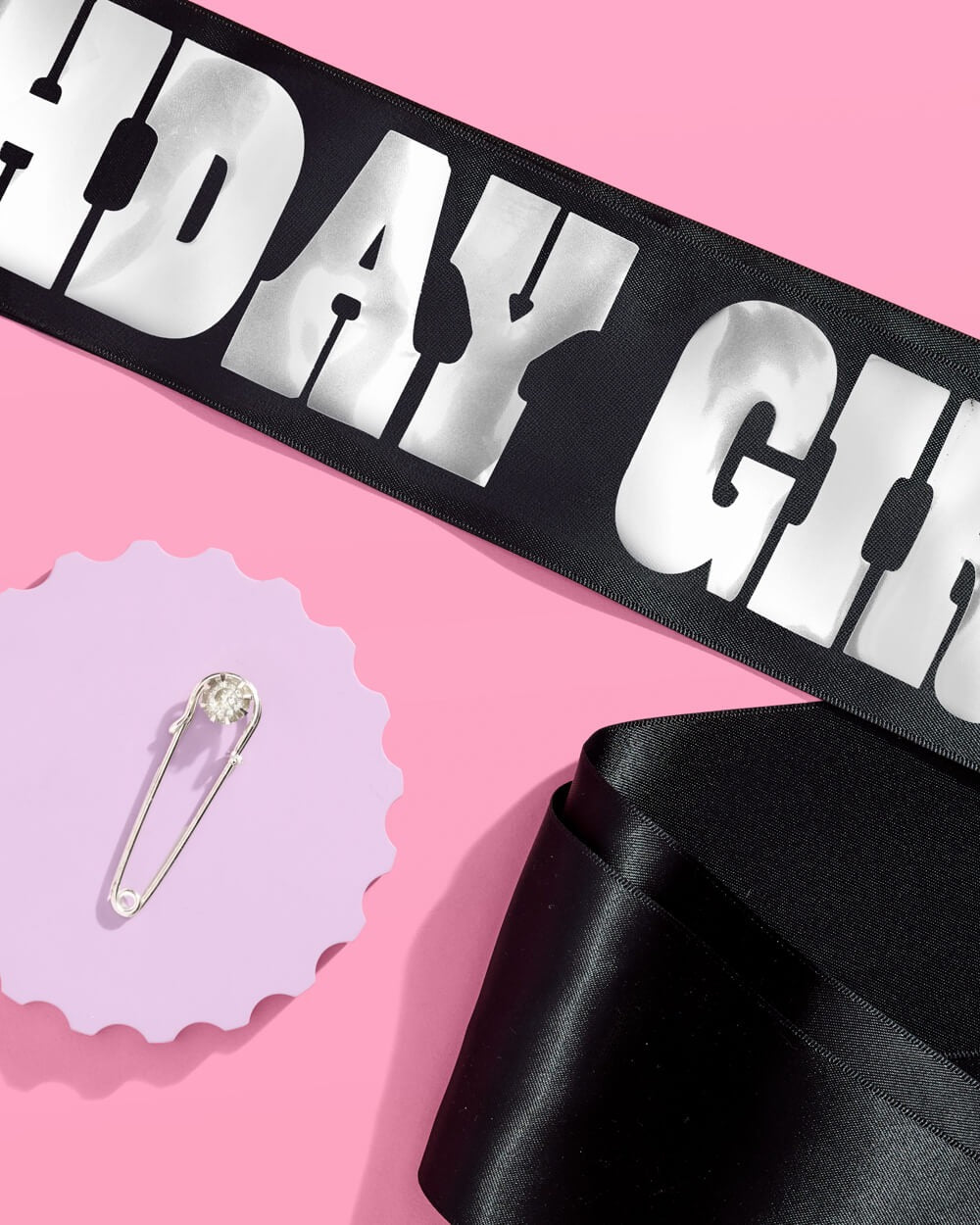 Black and silver birthday girl sash with safety pin on pink from Parte Haus party supply store in Bethesda Maryland